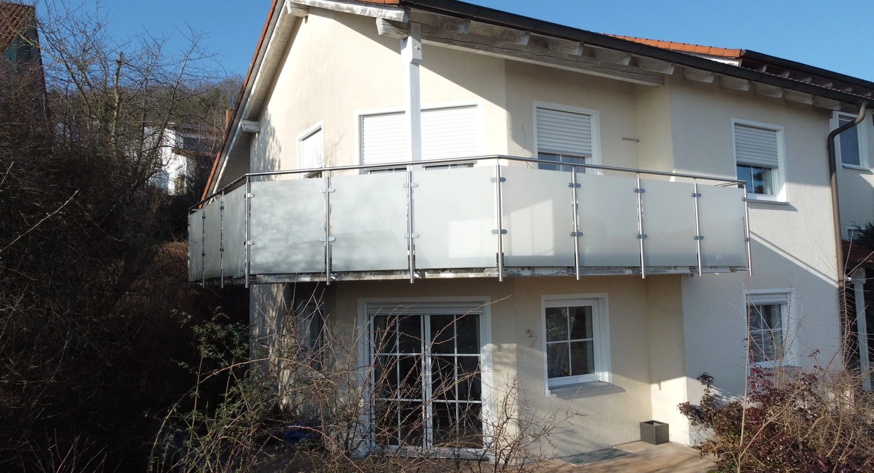 Geländerbausatz aus Edelstahl und Sicherheitsglas mit mattweißer Folie am Balkon montiert