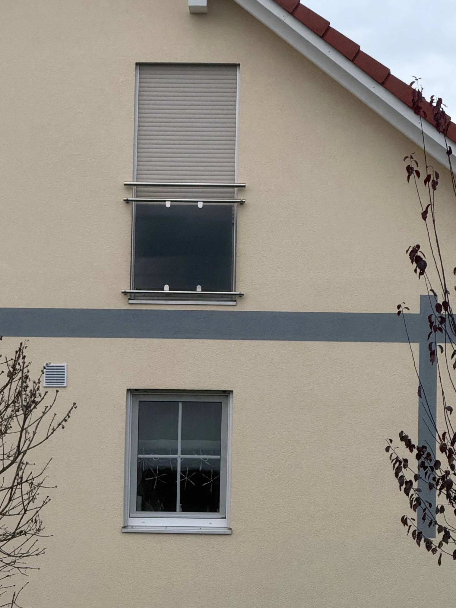 franzoesischer Balkon aus Edelstahl mit einer blickdichten Glasfuellung fuer mehr Privatsphaere