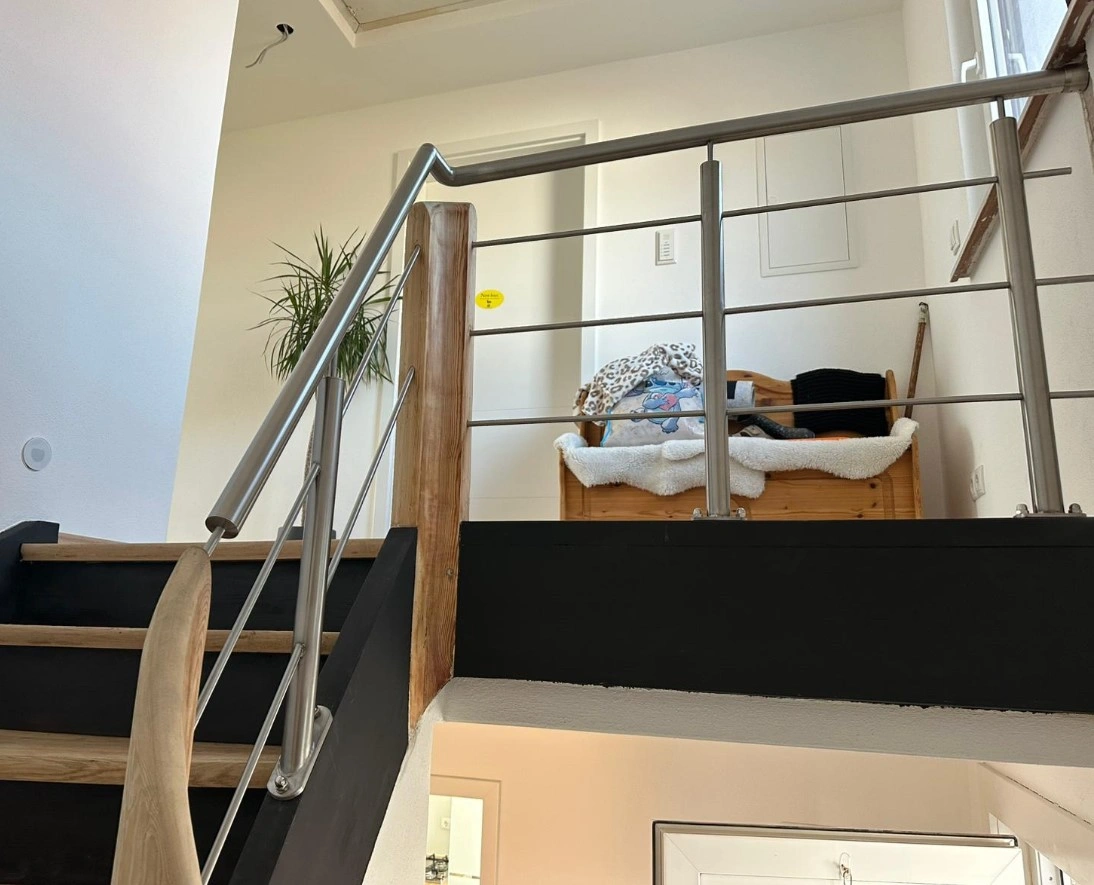 Relinggeländer aufgesetzt mit drei Querstreben auf einer renovierten Holztreppe im Haus