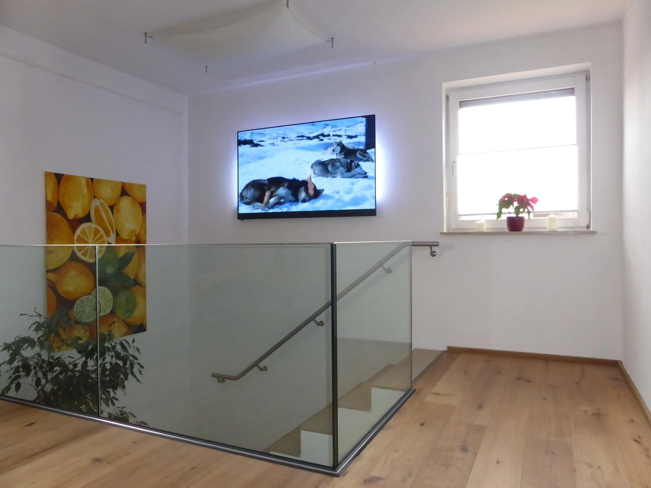 Elegantes Ganzglasgelaender im Innenraum mit Klarglas und einen Edelstahl Treppenhandlauf