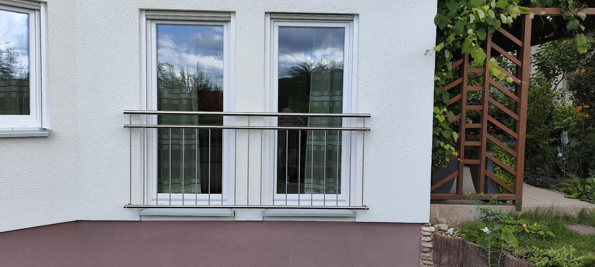 Extra großer franzoesischer Balkon vor zwei Fenster im Erdgeschoss als Sicherung der bodentiefen Fenster