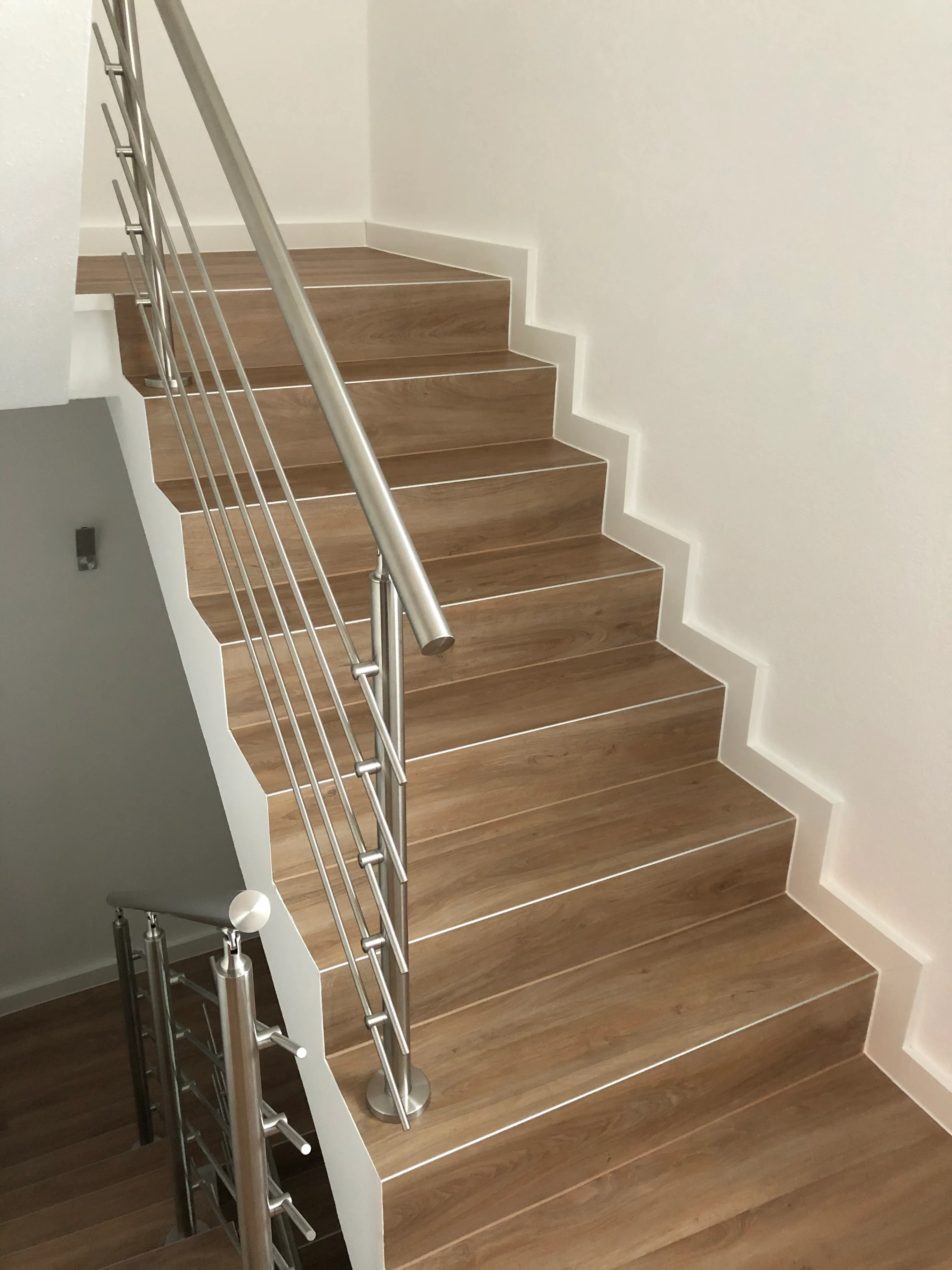 Relinggeländer aufgesetzt mit 5 Querstreben aus Edelstahl montiert auf einer Innentreppe als Absturzsicherung