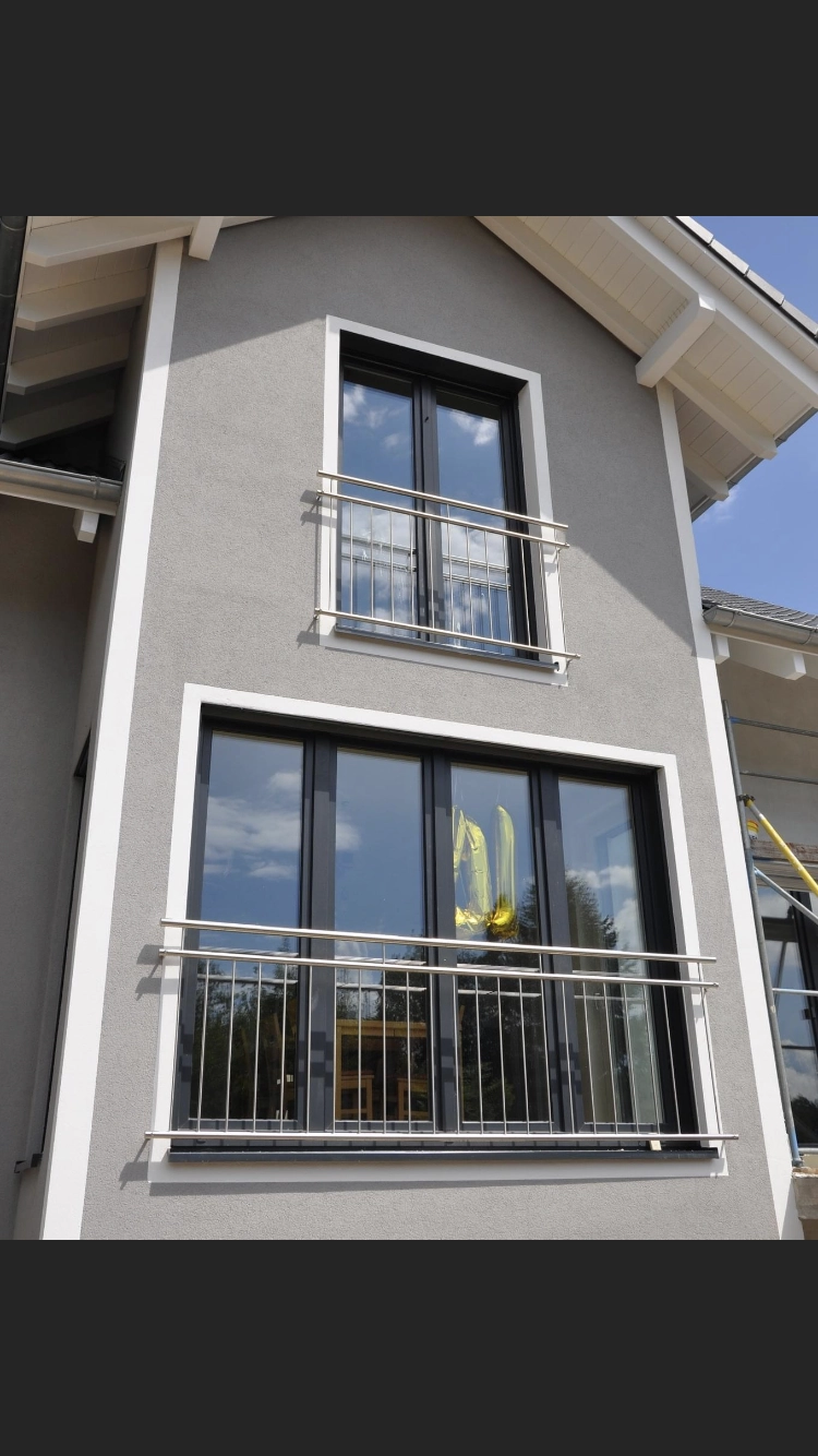 Zwei franzoesische Balkone die sich harmonisch in die Struktur des Hauses einfuegen und Sicherheit gewaehren