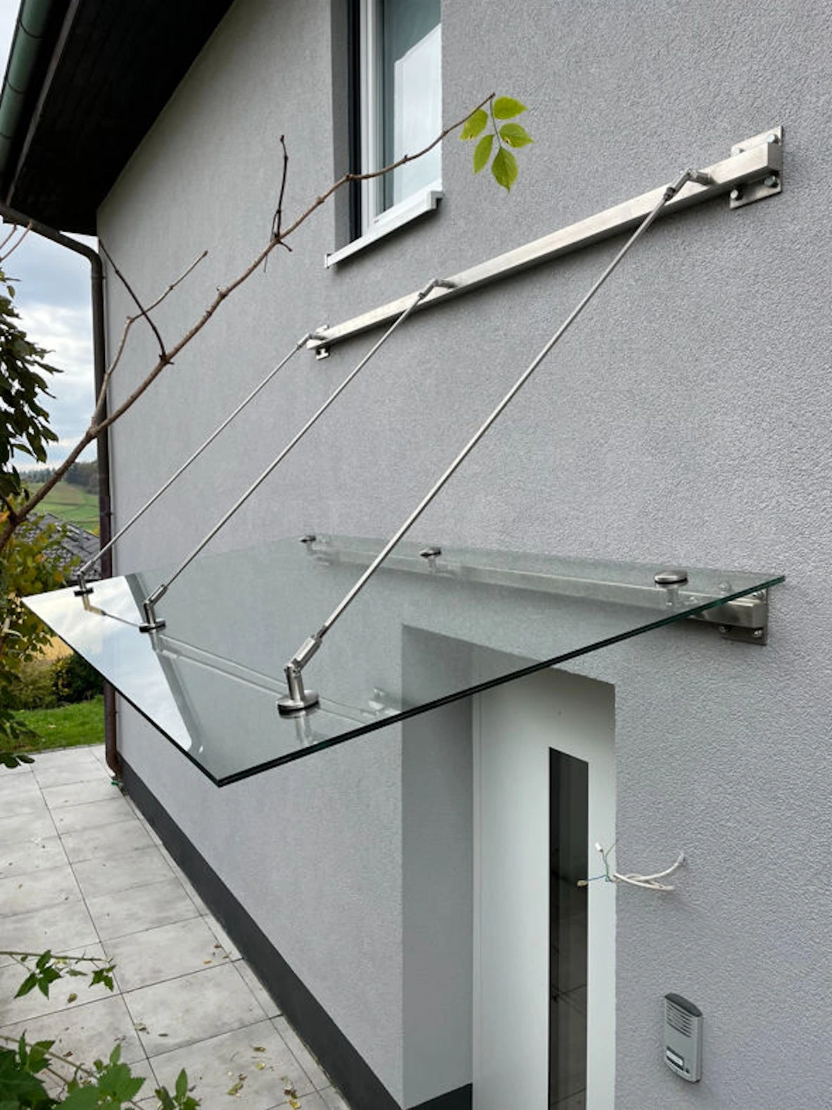 Großes Vordach aus Edelstahlkomponenten und Klarglas