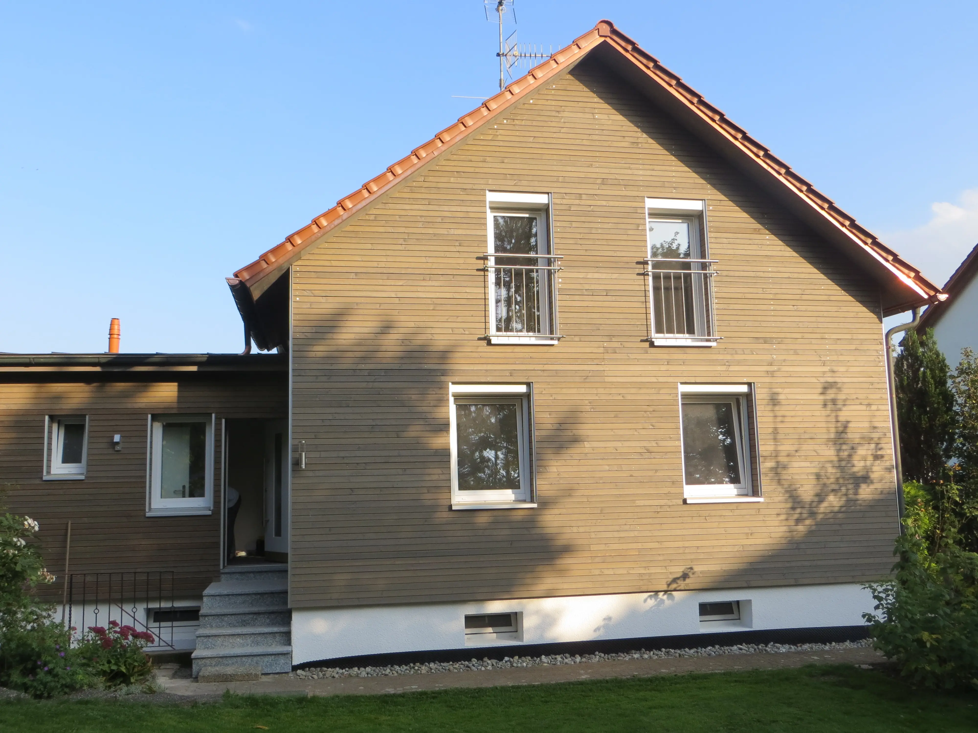 Franzoesische Balkone aus Edelstahl an einer Holzfassade zur Sicherung der bodentiefen Fenster